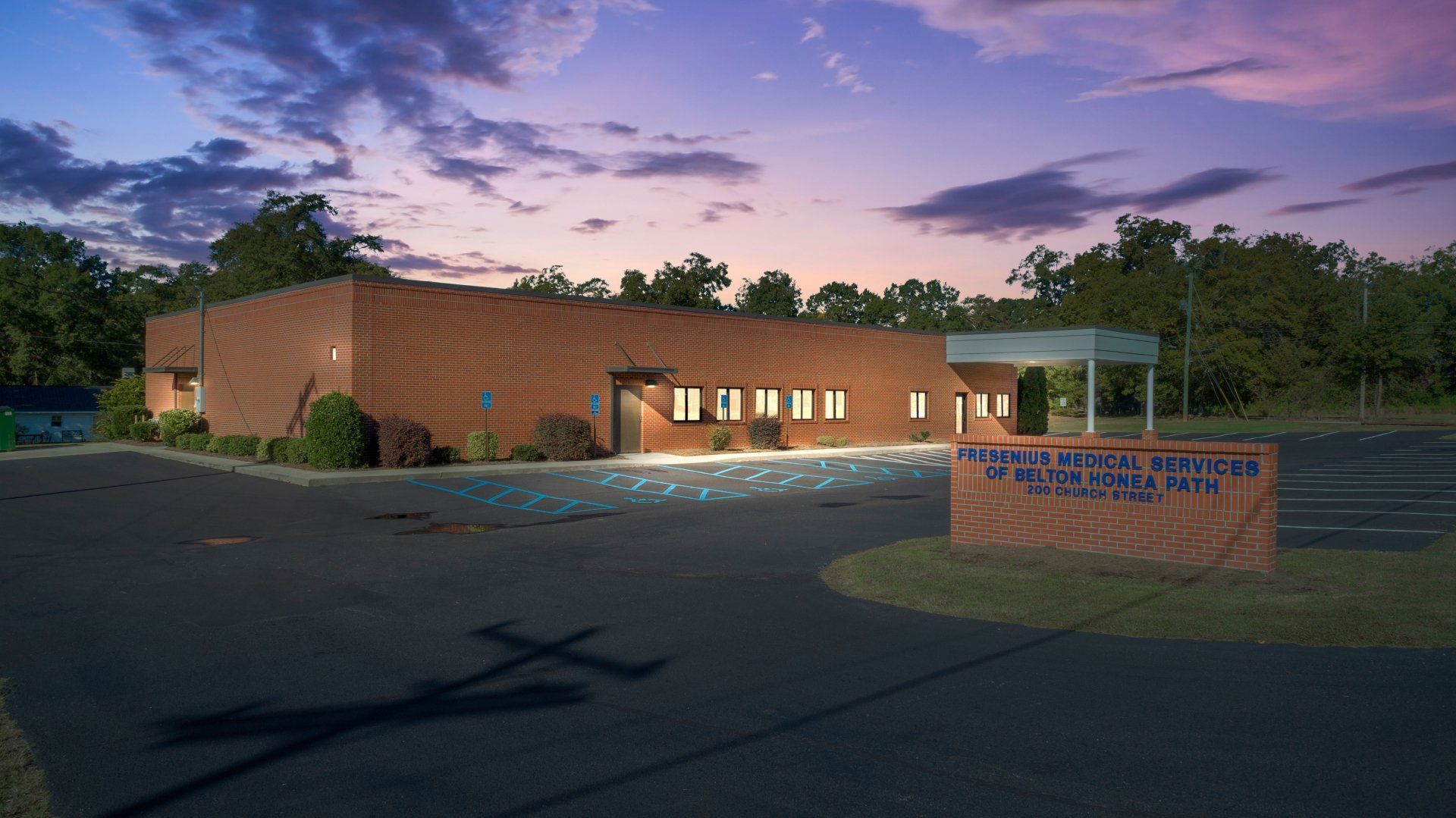 A brick building with a sign in front of it that says 'fresenius kidney care' on it.