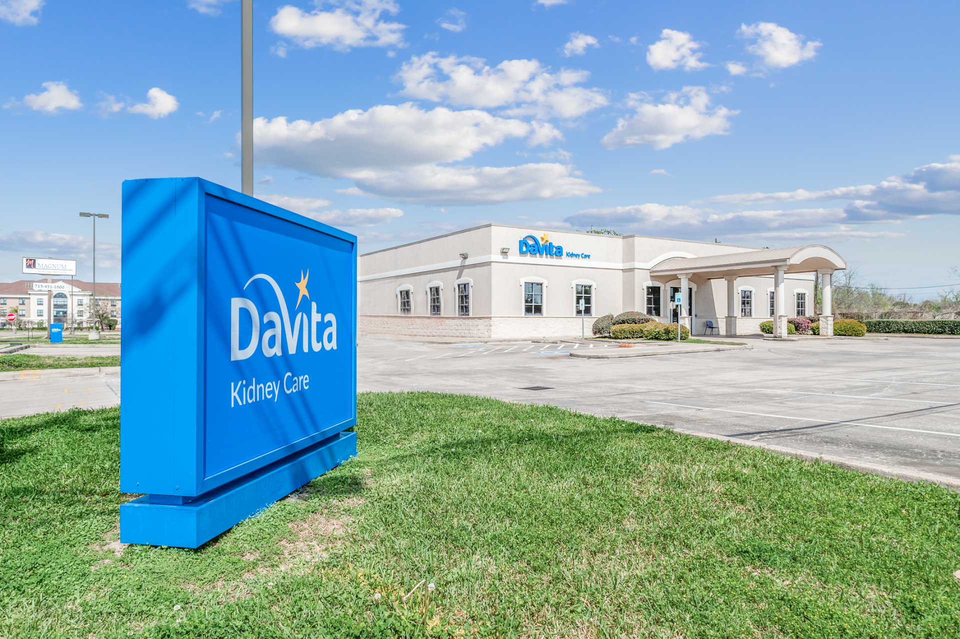 A blue sign for davita kidney care is in front of a building.
