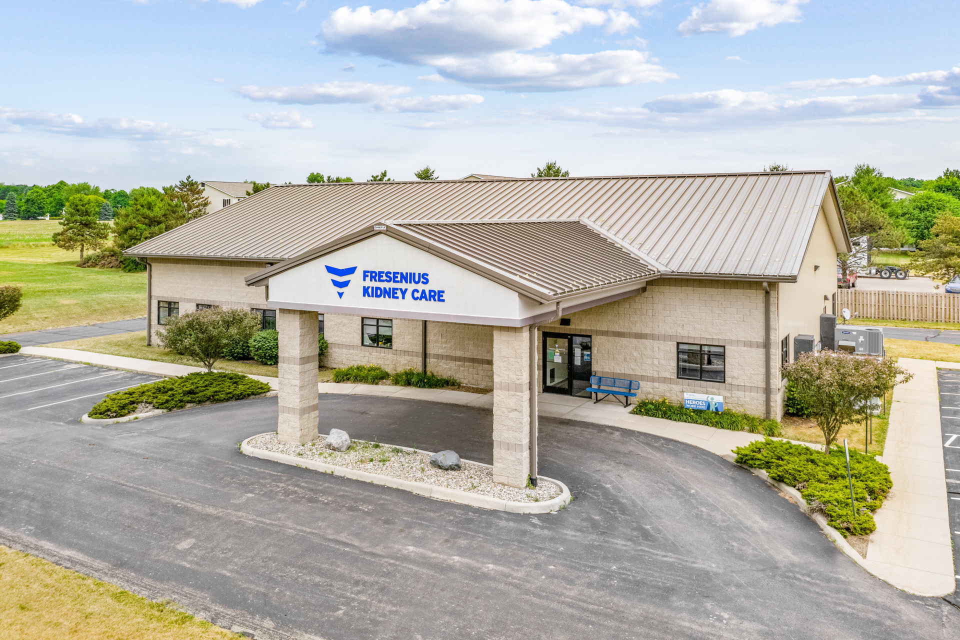 An aerial view of a large building with a blue awning over the entrance.