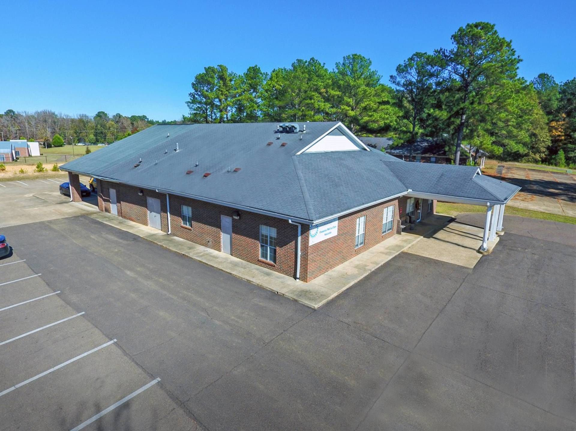 An aerial view of a large brick building with a parking lot.