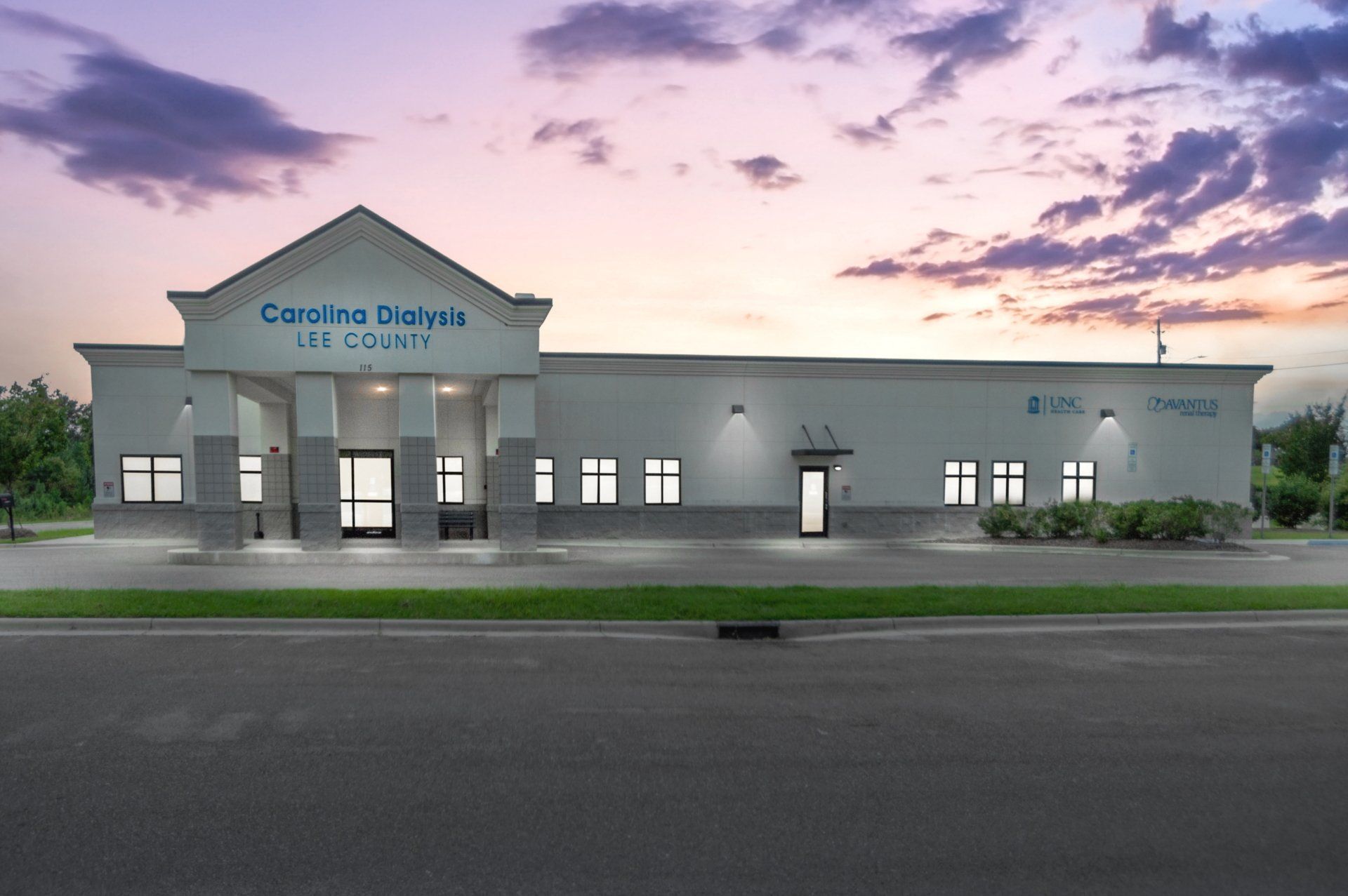 A large white building with a sunset in the background