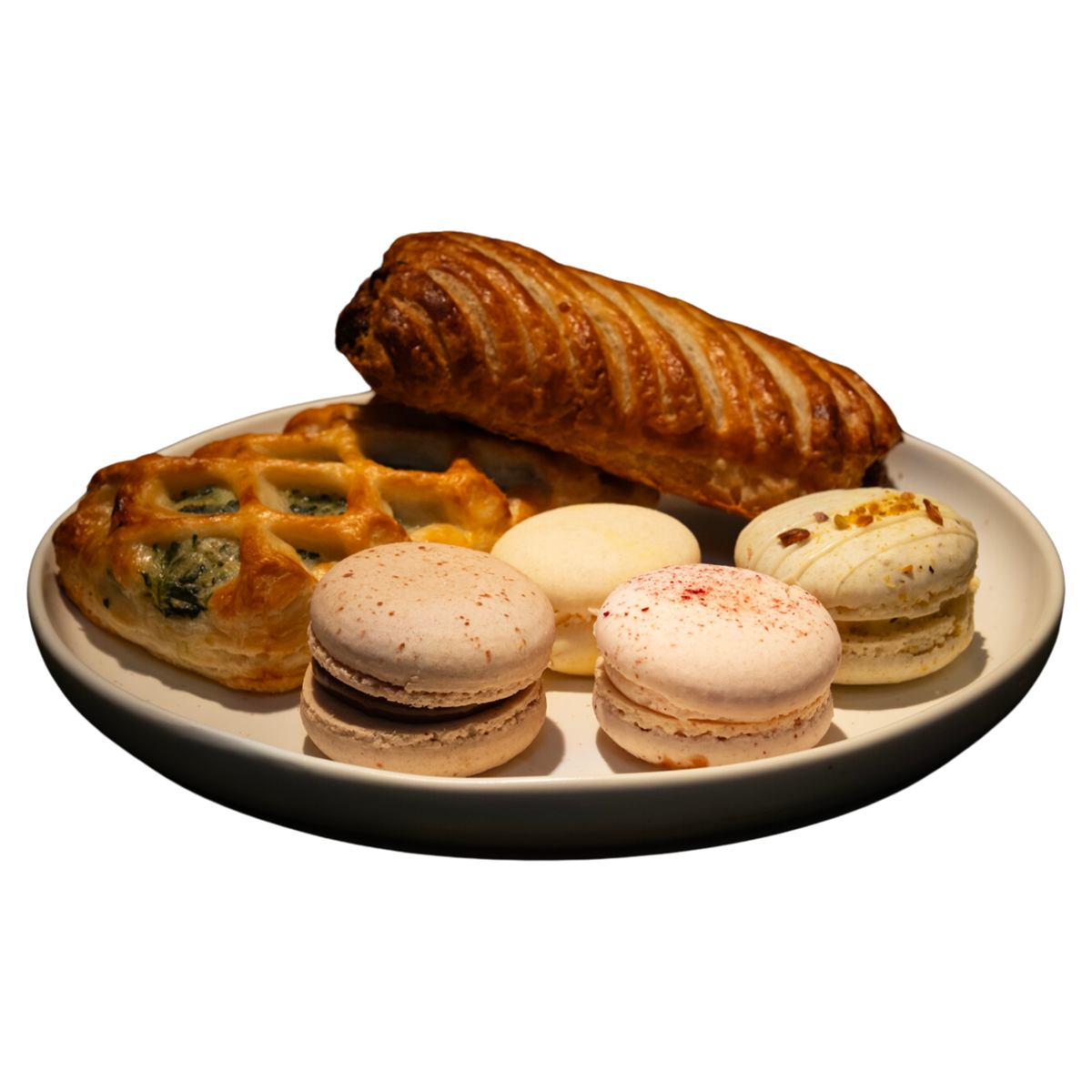 A white plate topped with a variety of pastries and macarons