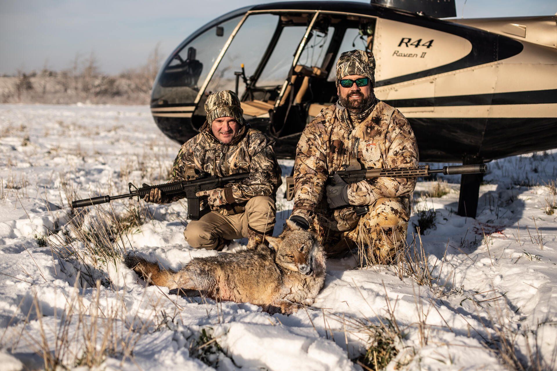 two hunters with a coyote
