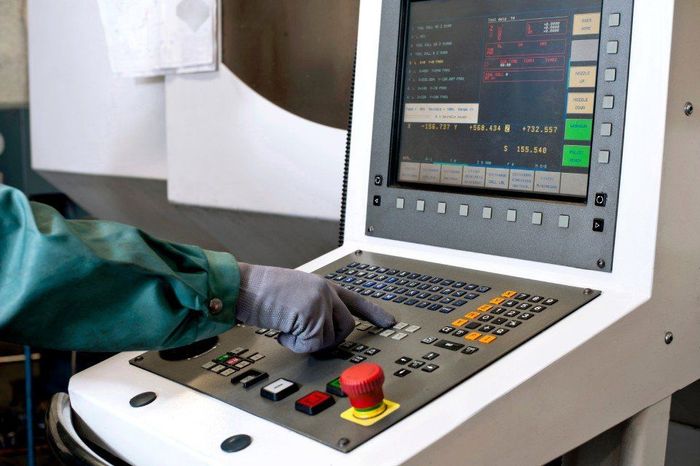 A person is pressing a red button on a machine