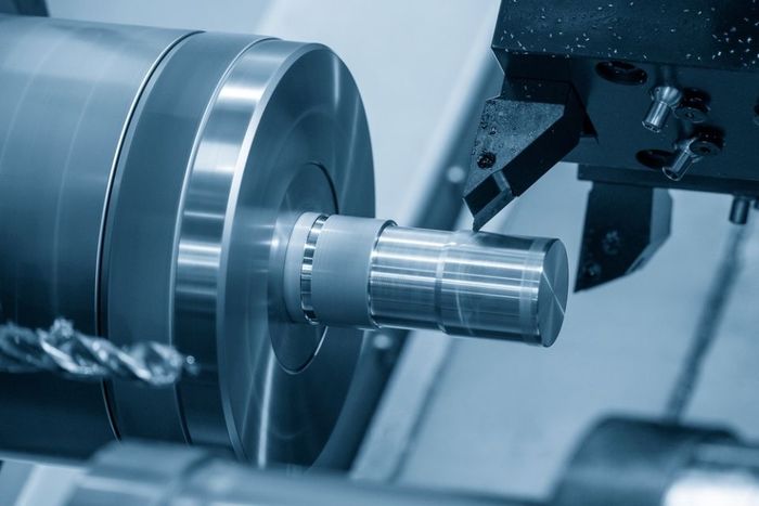 A machine is cutting a piece of metal with a drill.