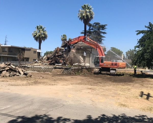 Excavation — Yellow Excavator Destroying House in Fresno, CA