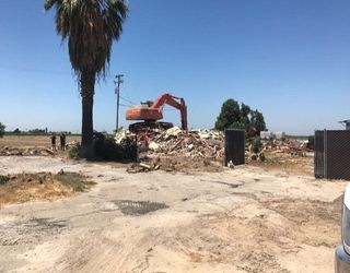 Land Clearing — Excavator Wrecking Building in Fresno, CA