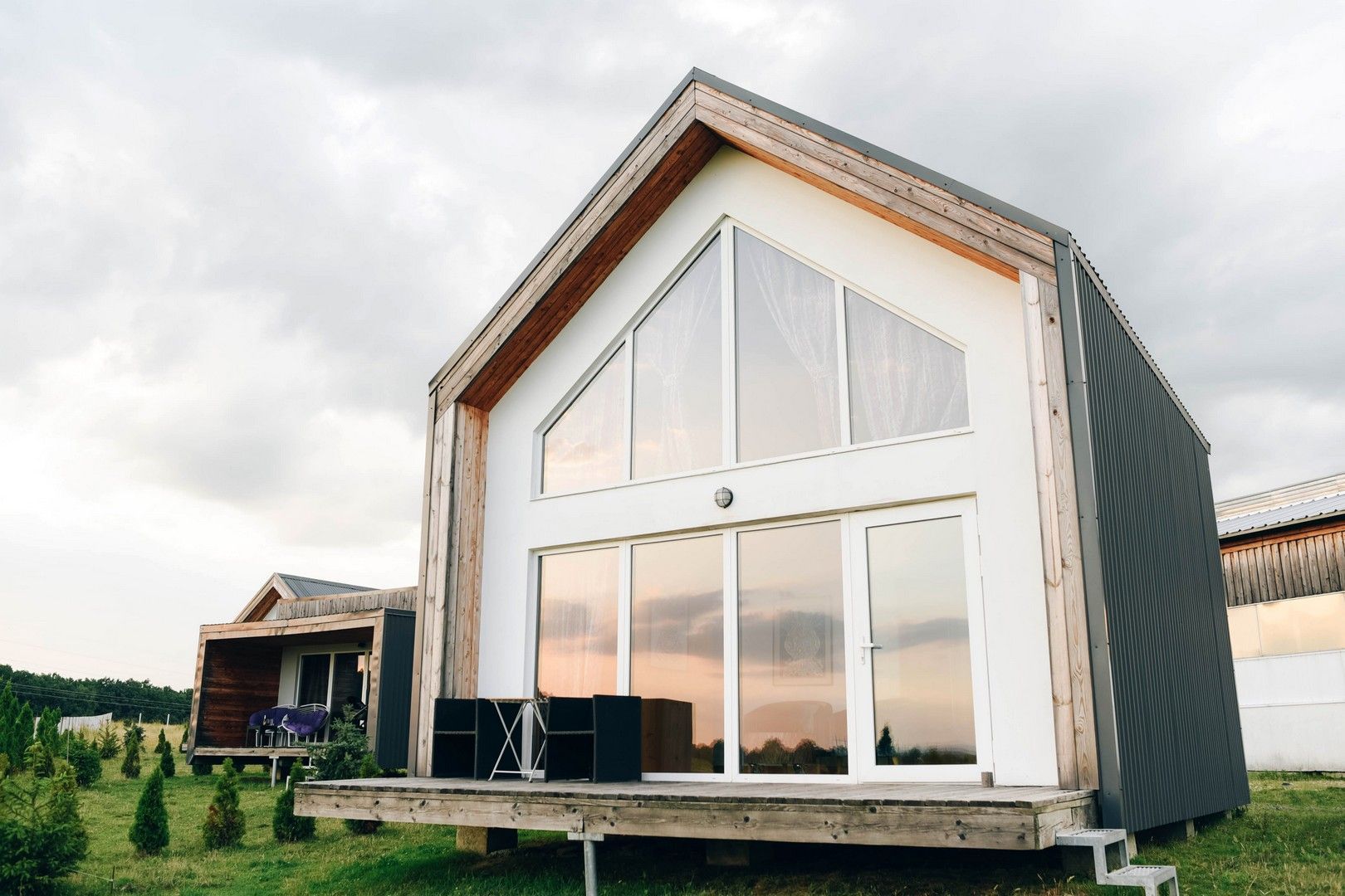Una piccola casa con tante finestre si trova in mezzo a un campo.