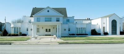 A large white house with a lawn in front of it