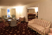 A living room with a couch , chairs , a table and a piano.