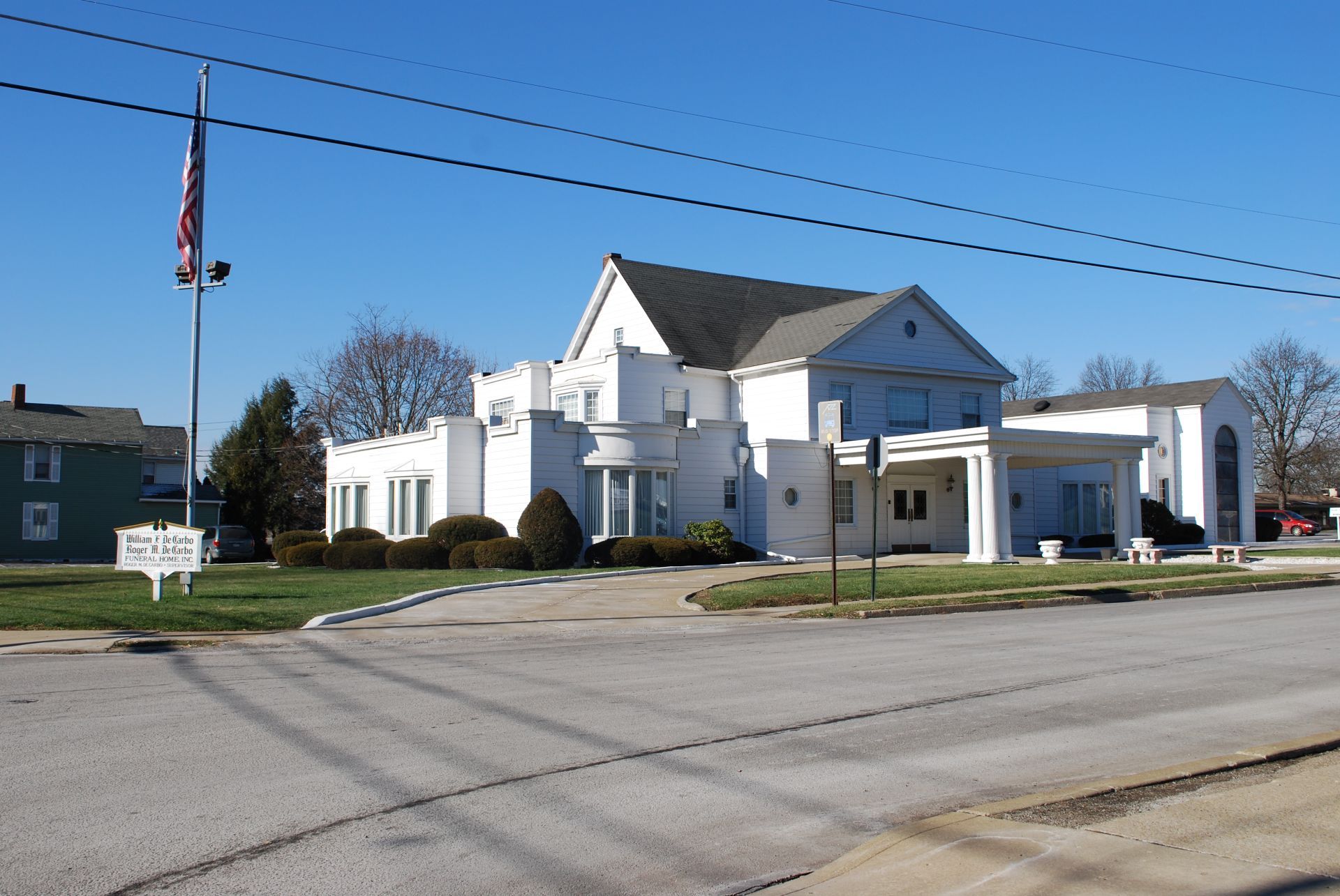 A white house with a sign that says ' funeral home ' on it