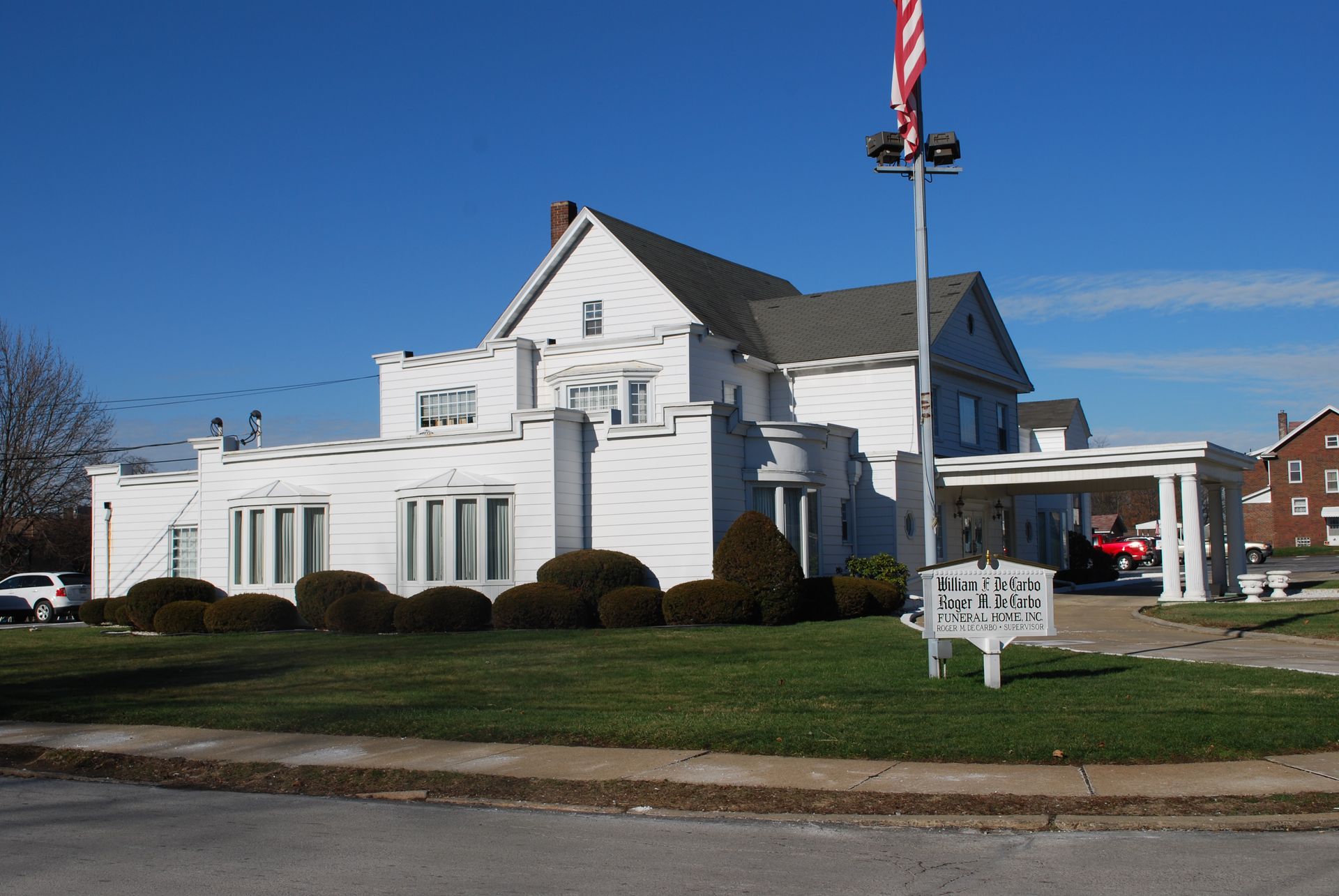 A large white house with a flag in front of it