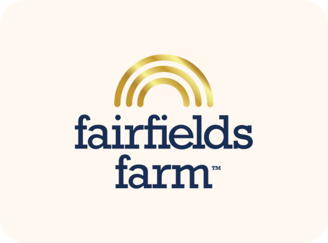 Fairfields Farm logo: Gold arch over dark blue text "fairfields farm™" on a cream background.