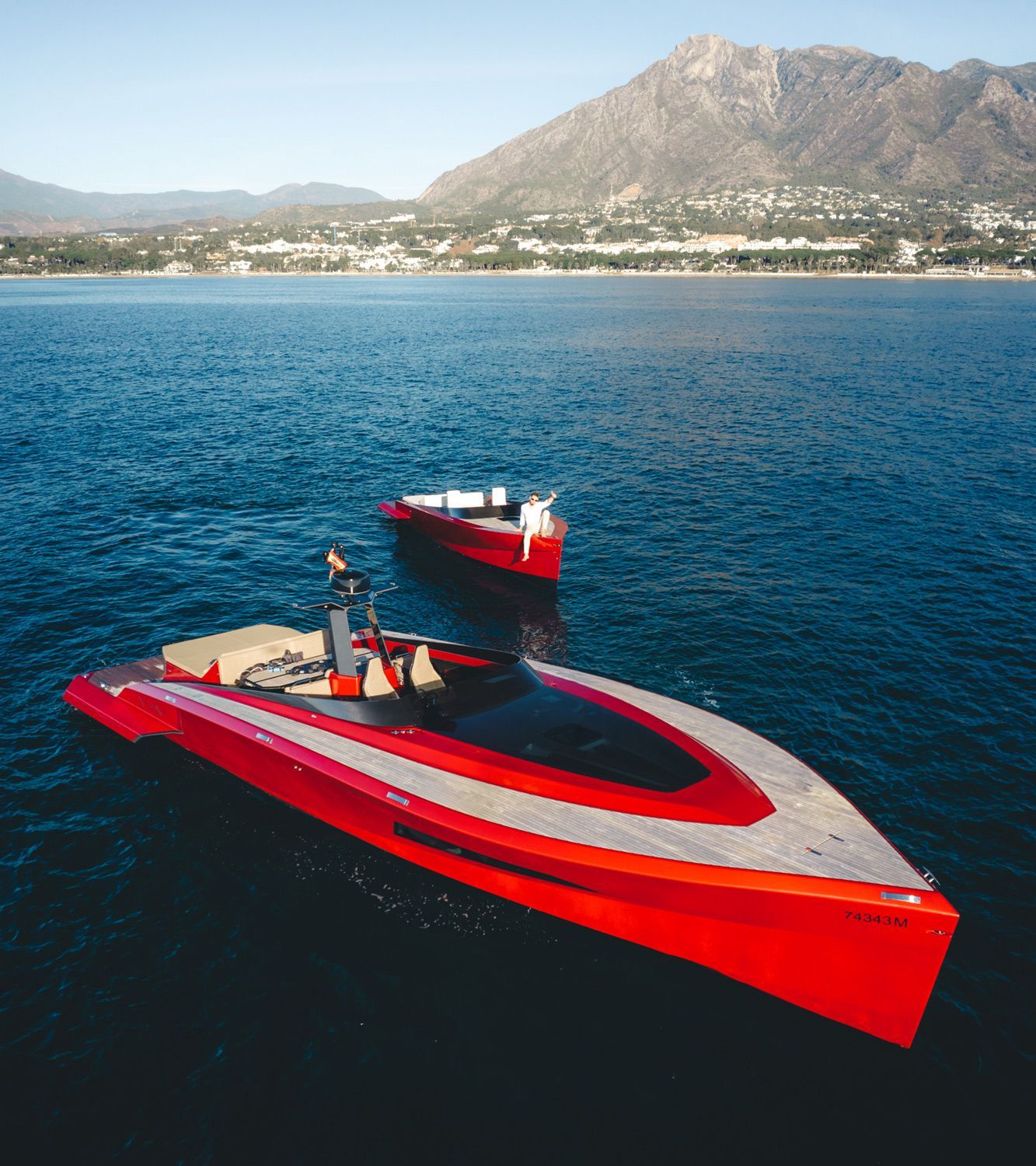 Aerial view of two red luxury yachts on turquoise waters off the Marbella coast