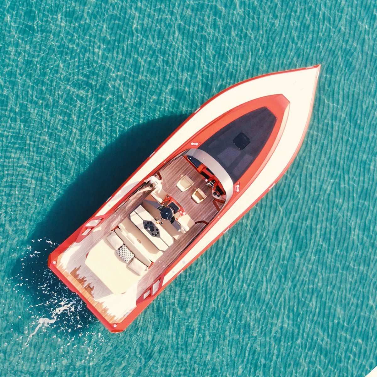 Aerial view of a red luxury yacht on turquoise waters off the Marbella coast