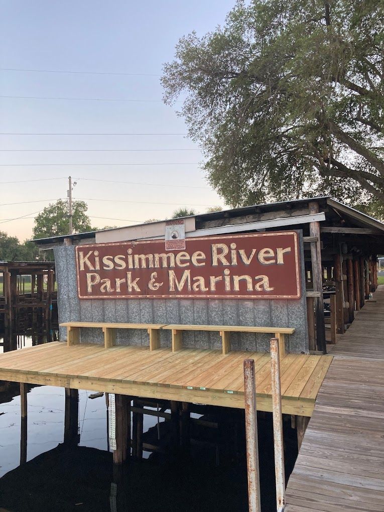 A dock with a sign that says kissimmee river park & marina