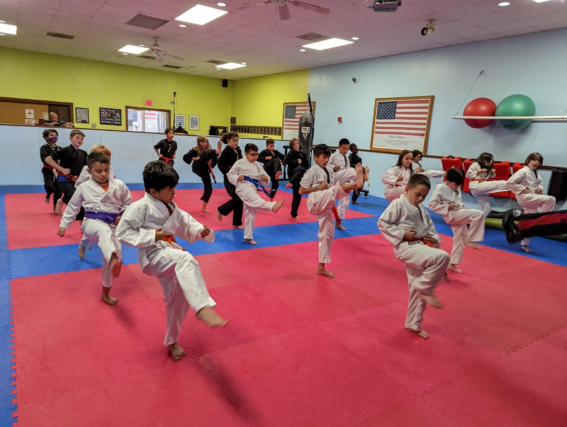 a group of kids are practicing martial arts in a gym