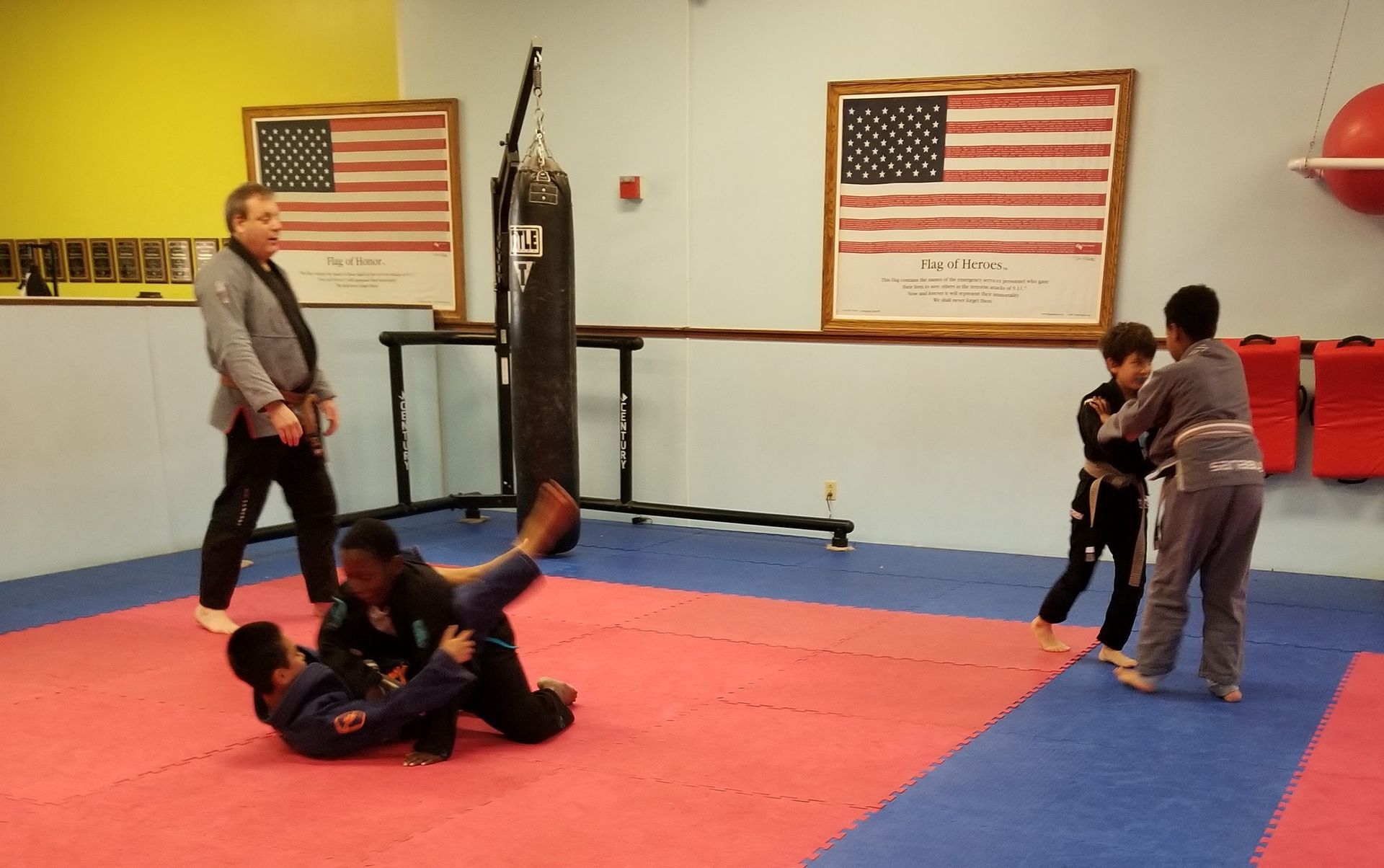 Two young boys in karate uniforms are standing next to each other in a dark room.