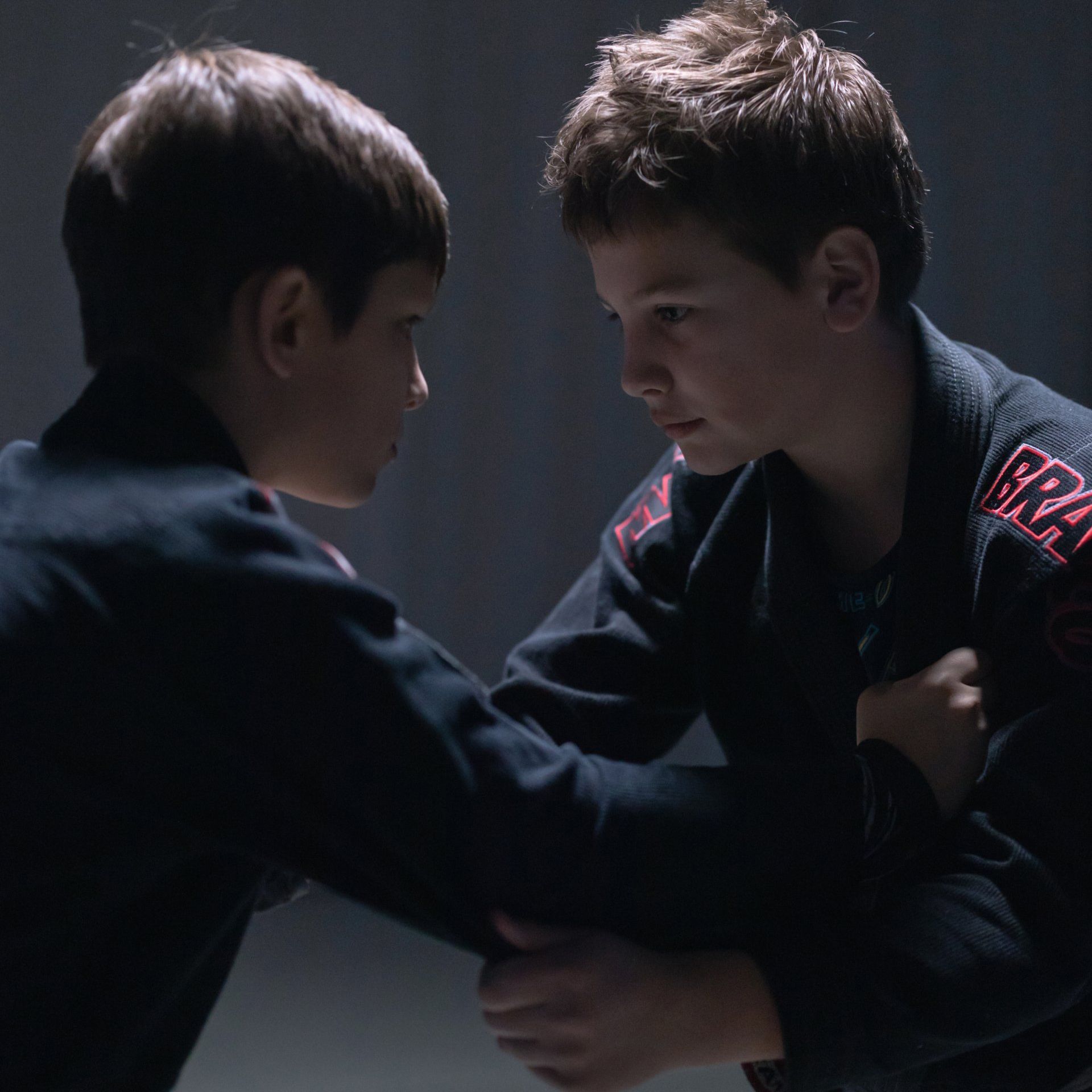 two boys wrestling with one wearing a shirt that says ' gpa ' on the sleeve