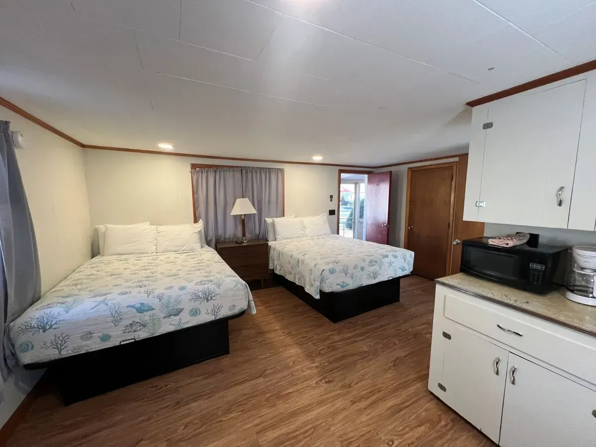 A hotel room with two beds and a microwave