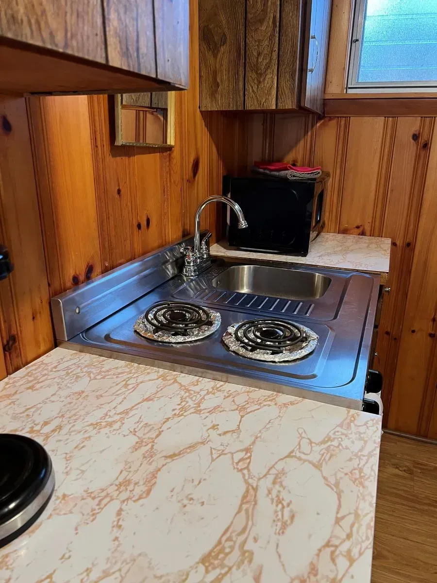 A kitchen with a stove , sink , and microwave.