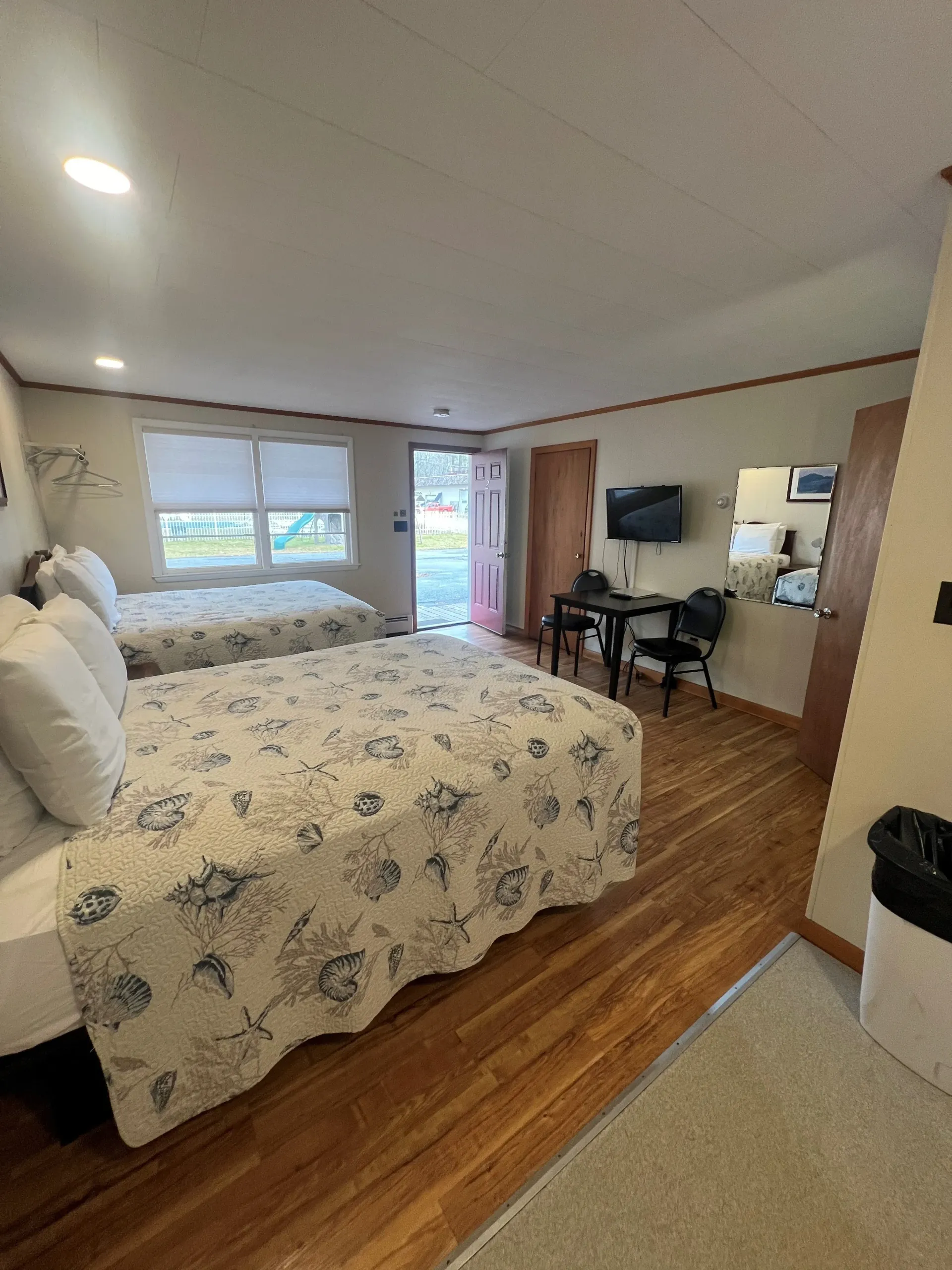 A hotel room with two beds , a table and chairs.