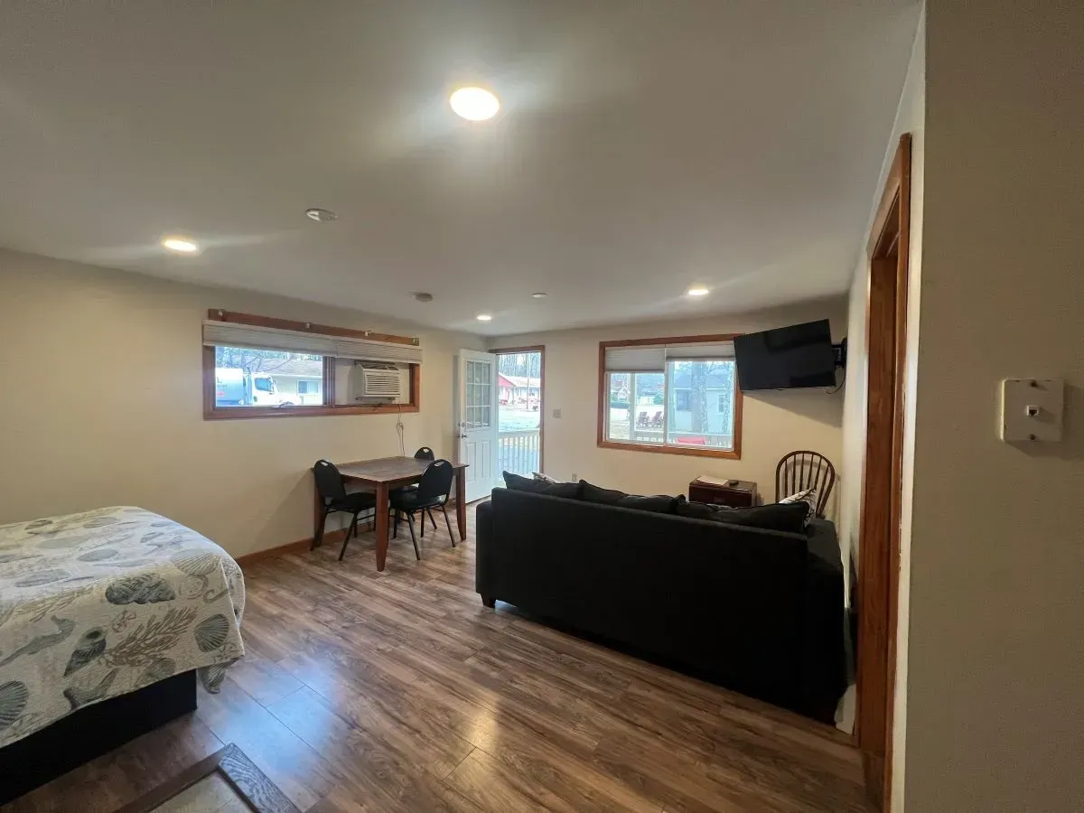 A living room with a bed , couch , table and chairs.