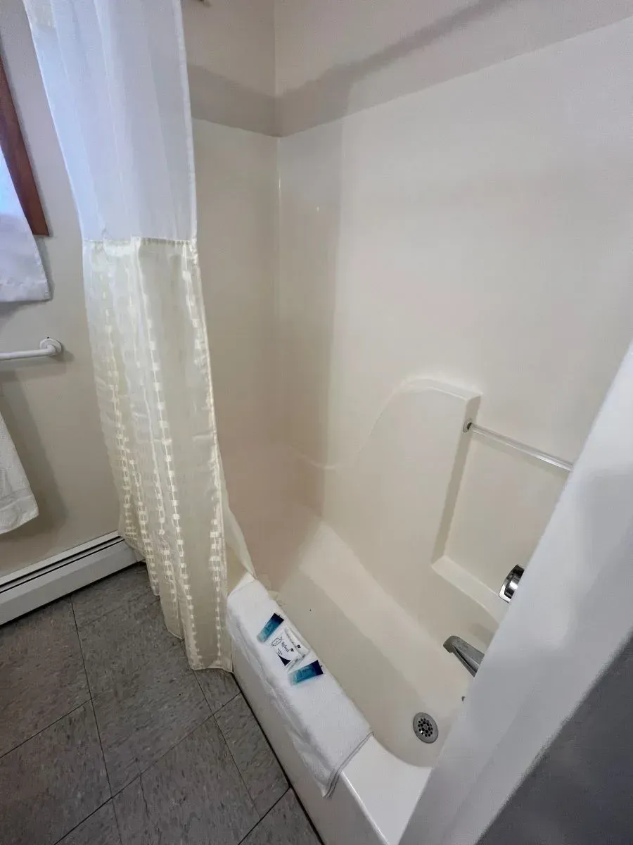 There is a bathtub in the bathroom with a shower curtain.