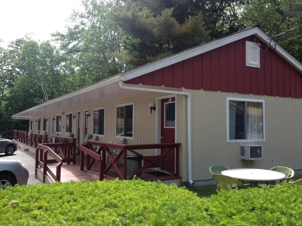 A small house with a red roof and white trim