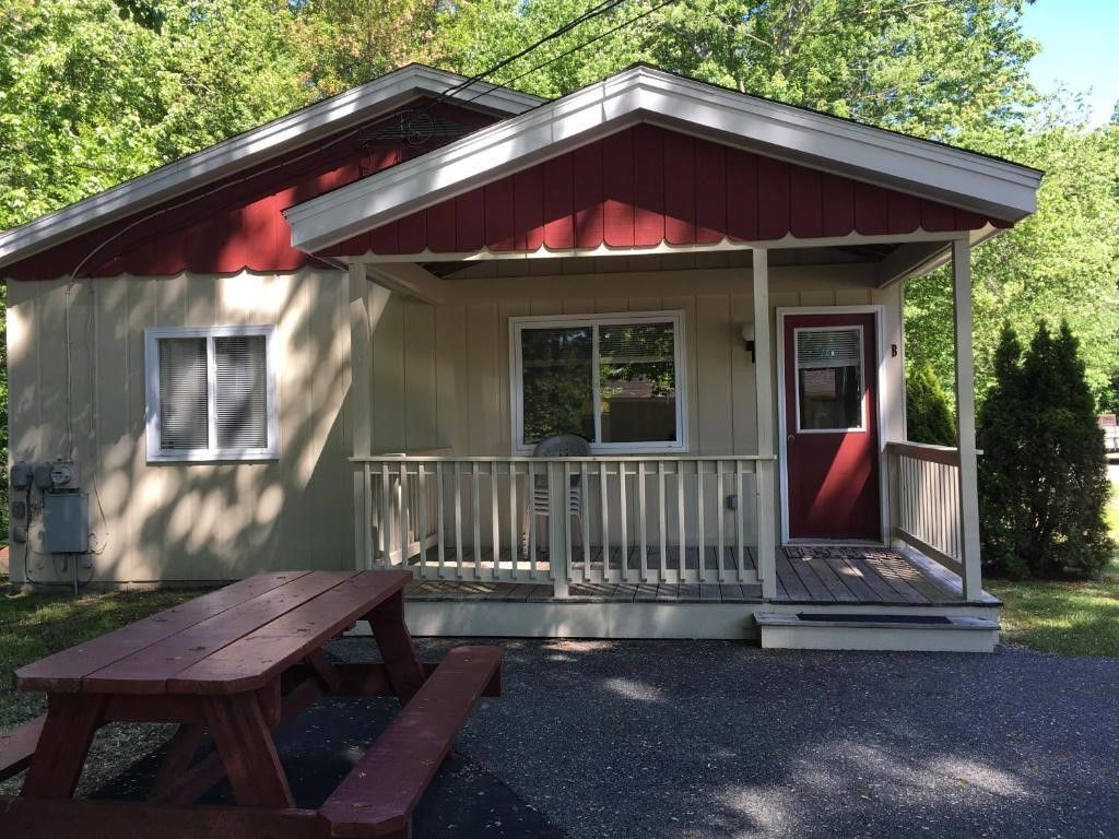 A small house with a picnic table in front of it