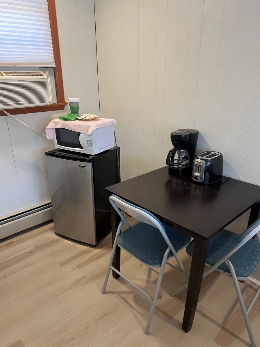 A kitchen with a table and chairs and a microwave