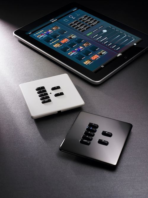 Tablet displaying control interface next to white and black light switch panels.