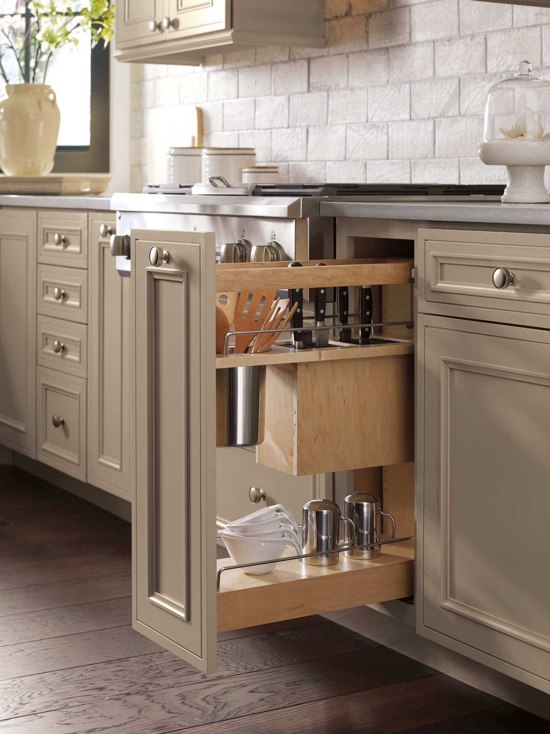 A kitchen with a pull out drawer filled with pots and pans