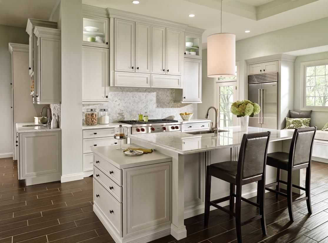 A kitchen with white cabinets and a large island in the middle.