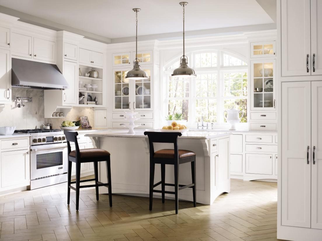 A kitchen with white cabinets and a large island