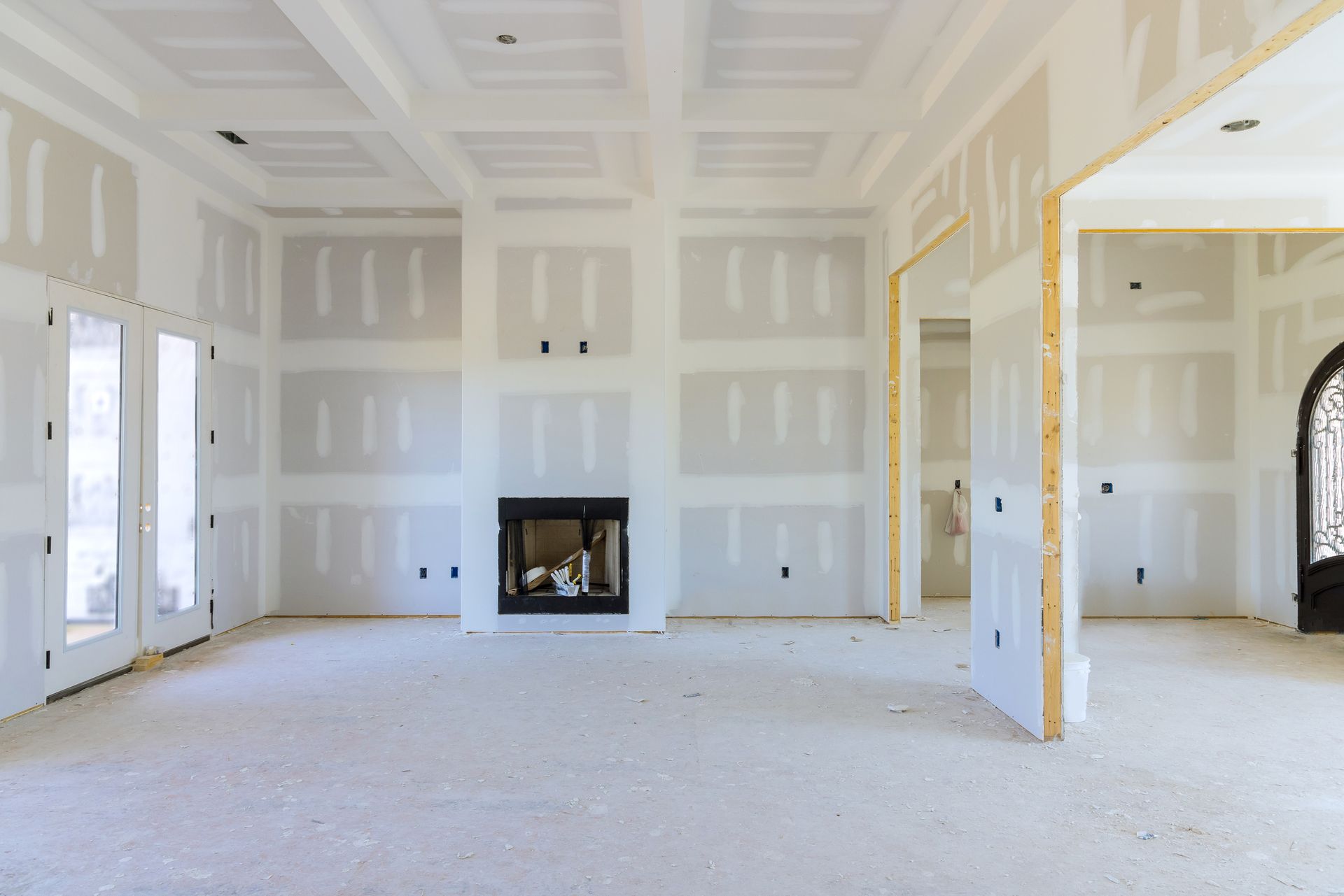 Interior of a room under construction, with drywall covering walls and ceiling.