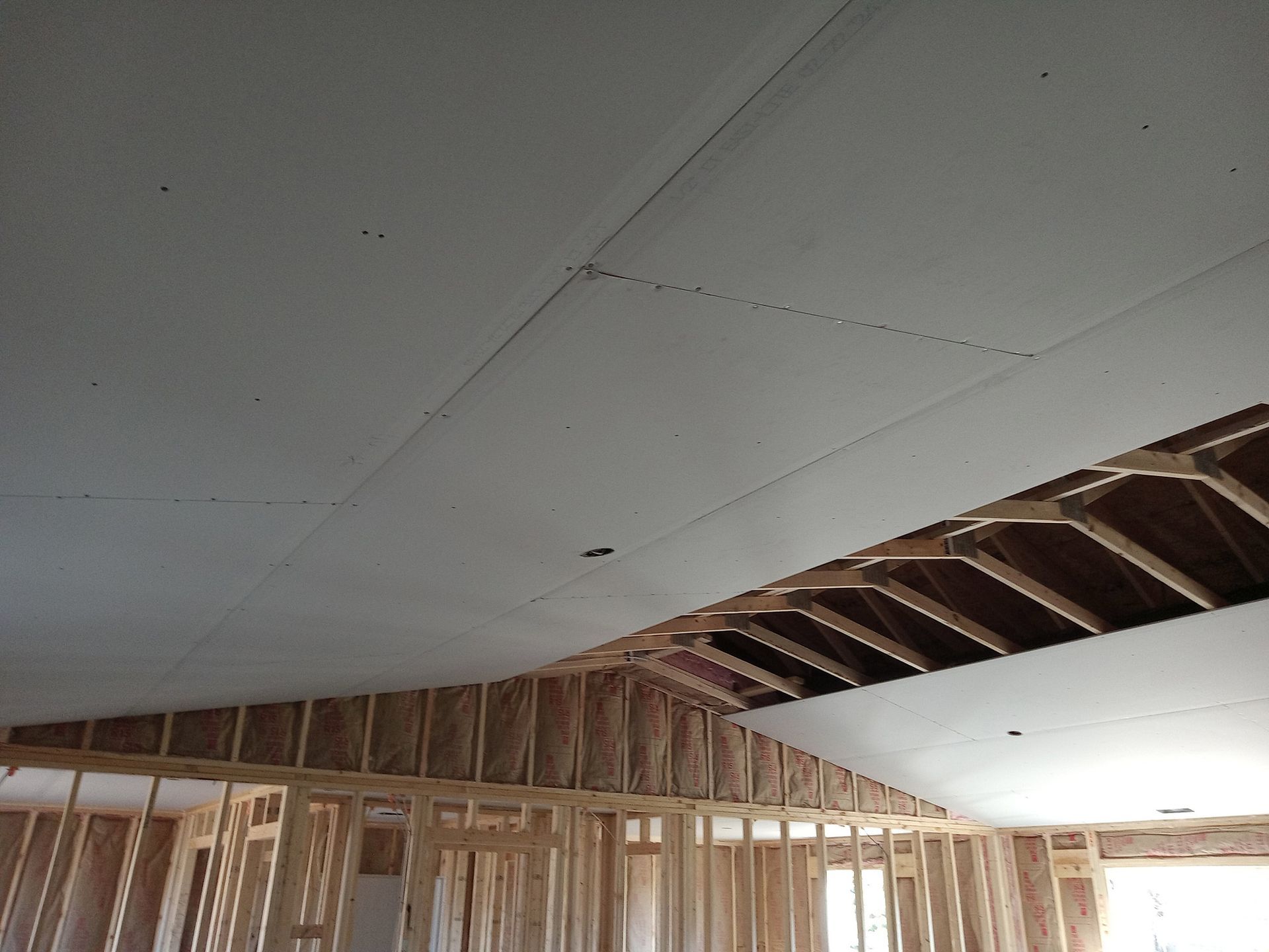 Interior framing with drywall partially installed on the ceiling and walls, during construction. Interior framing with drywall partially installed on the ceiling and walls, during construction.