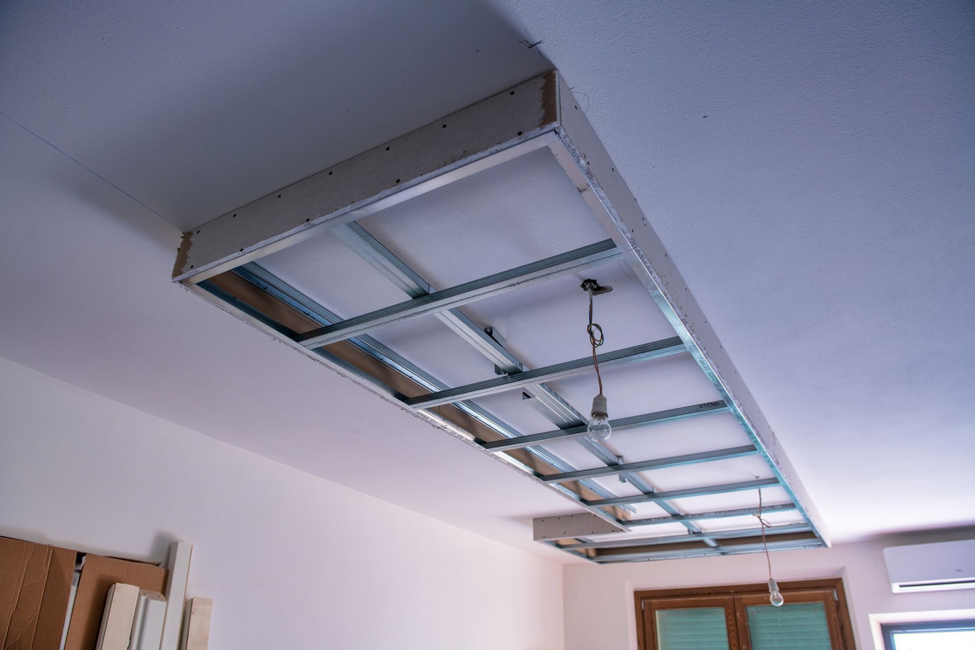 Metal framework for a recessed ceiling, with drywall installed partially. Metal framework for a recessed ceiling, with drywall installed partially.