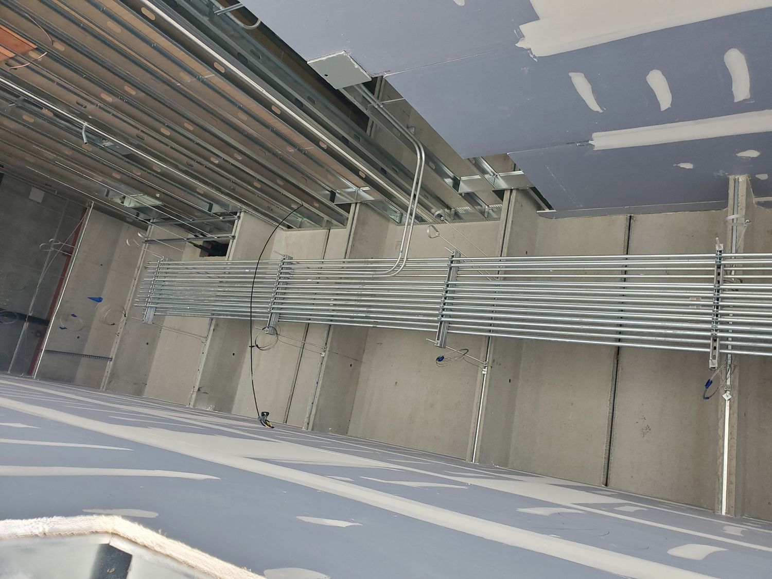 Metal conduits and support structures within a building’s unfinished ceiling. Metal conduits and support structures within a building’s unfinished ceiling.