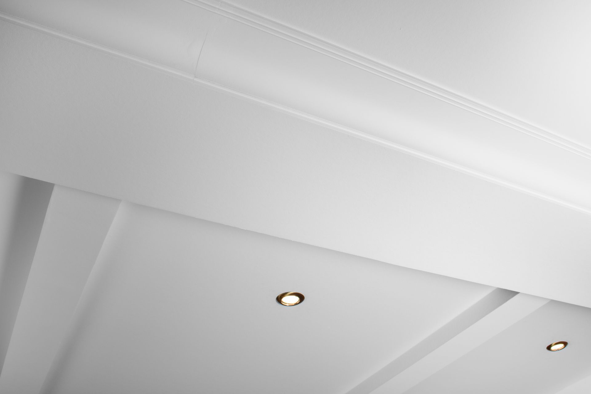 White ceiling with recessed lighting and molding details. White ceiling with recessed lighting and molding details.