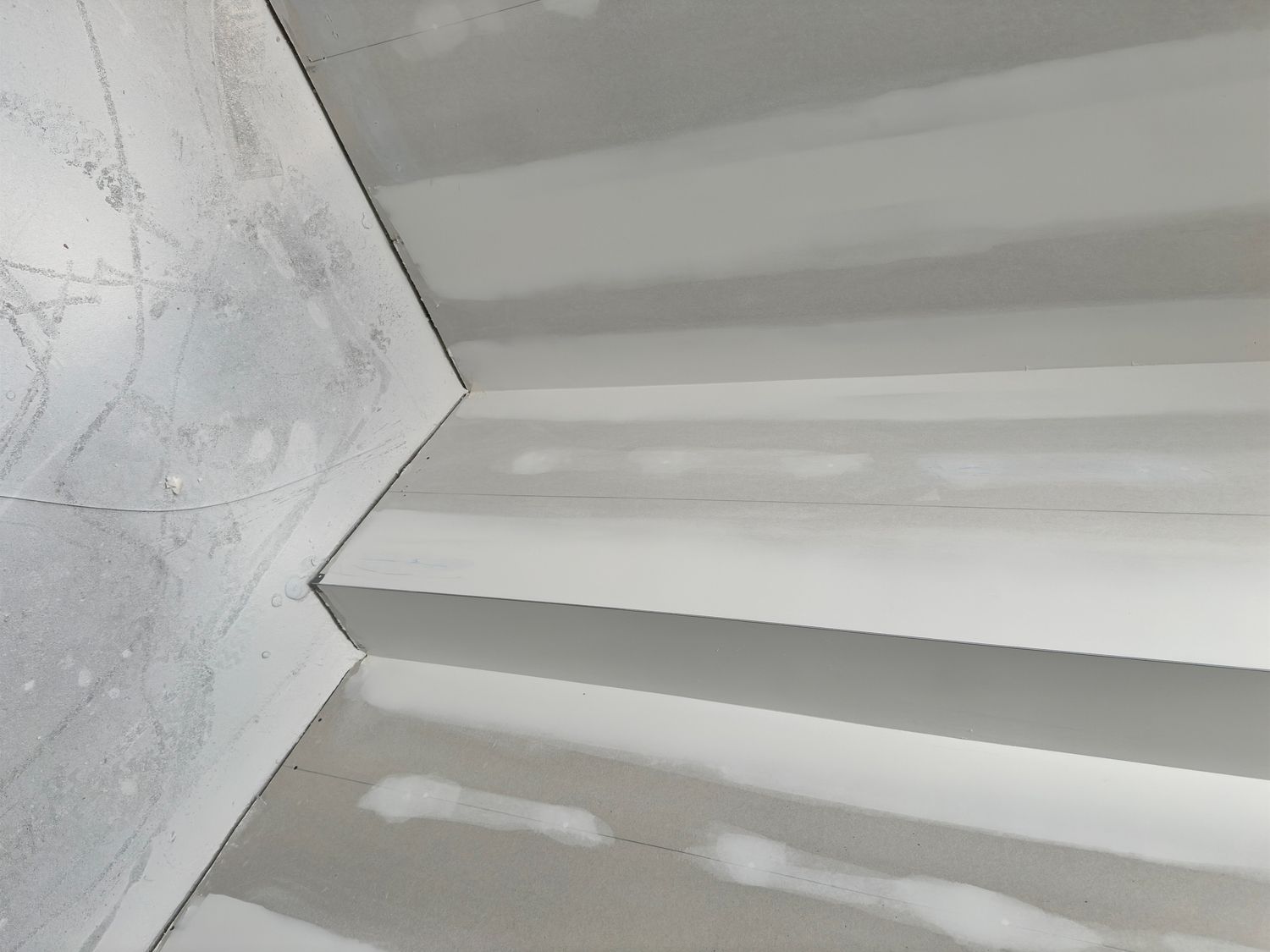 White drywall corner of stairs in construction with joint compound.