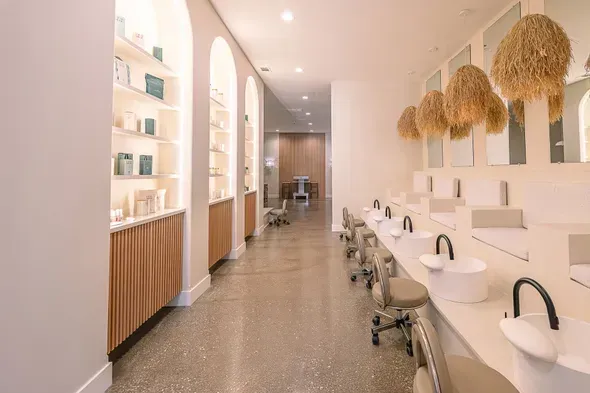A long hallway with a lot of sinks and mirrors.