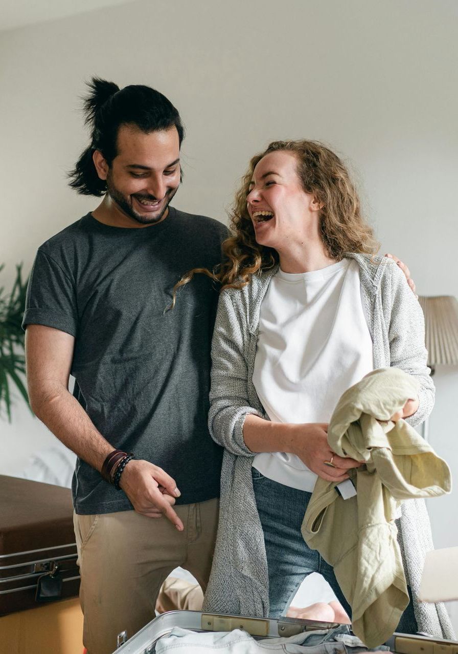 A man and a woman are standing next to each other in a living room.