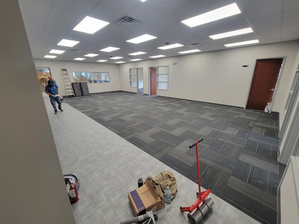 A large room with a carpeted floor and a blue wall.