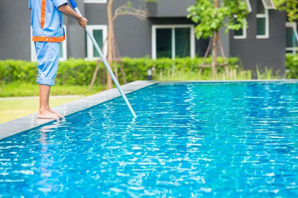 A Man is Cleaning a Swimming Pool — Billabong Pool Service & Supply Pty Ltd in Buderim, QLD