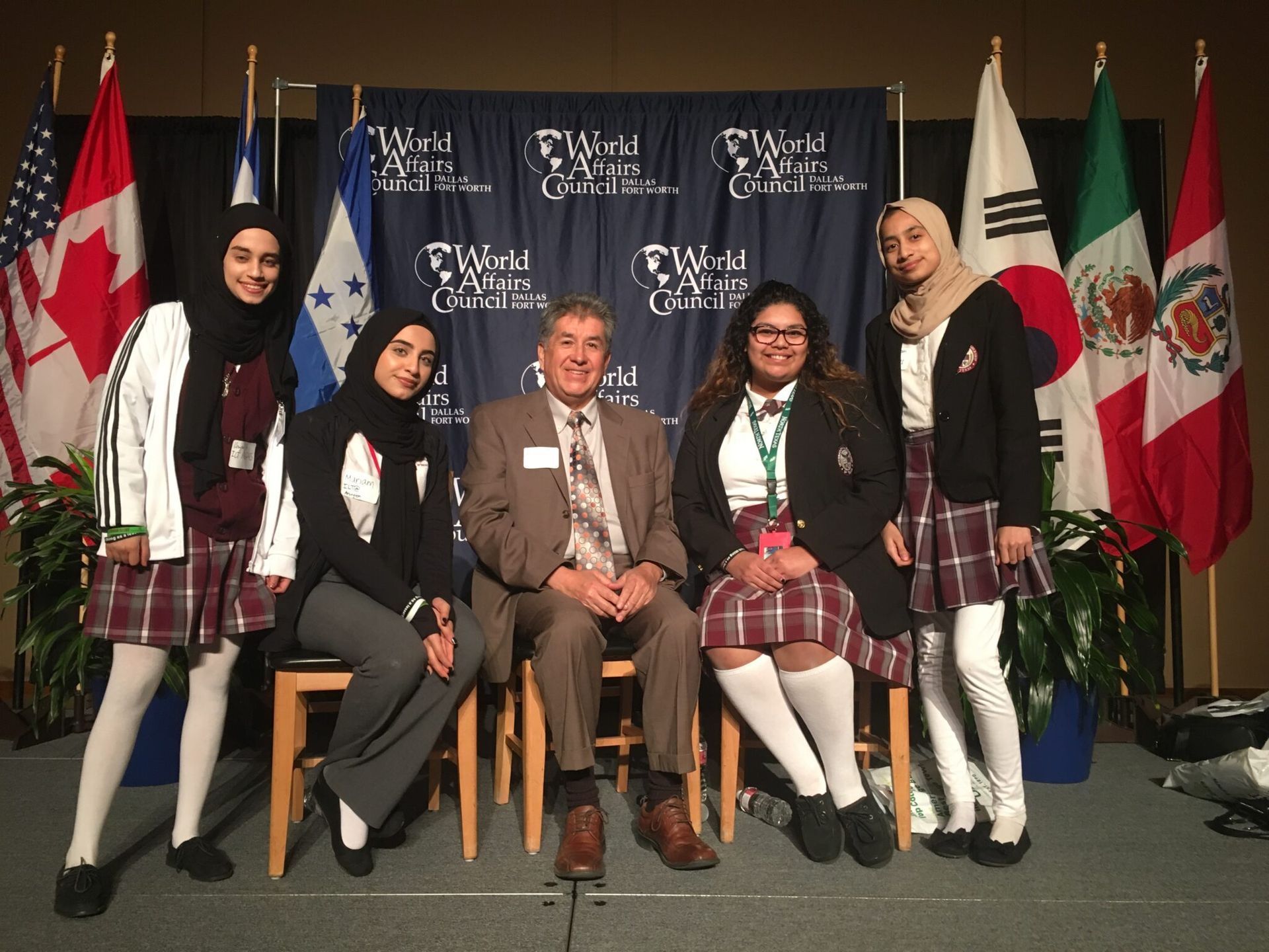 A group of people posing for a picture with flags in the background
