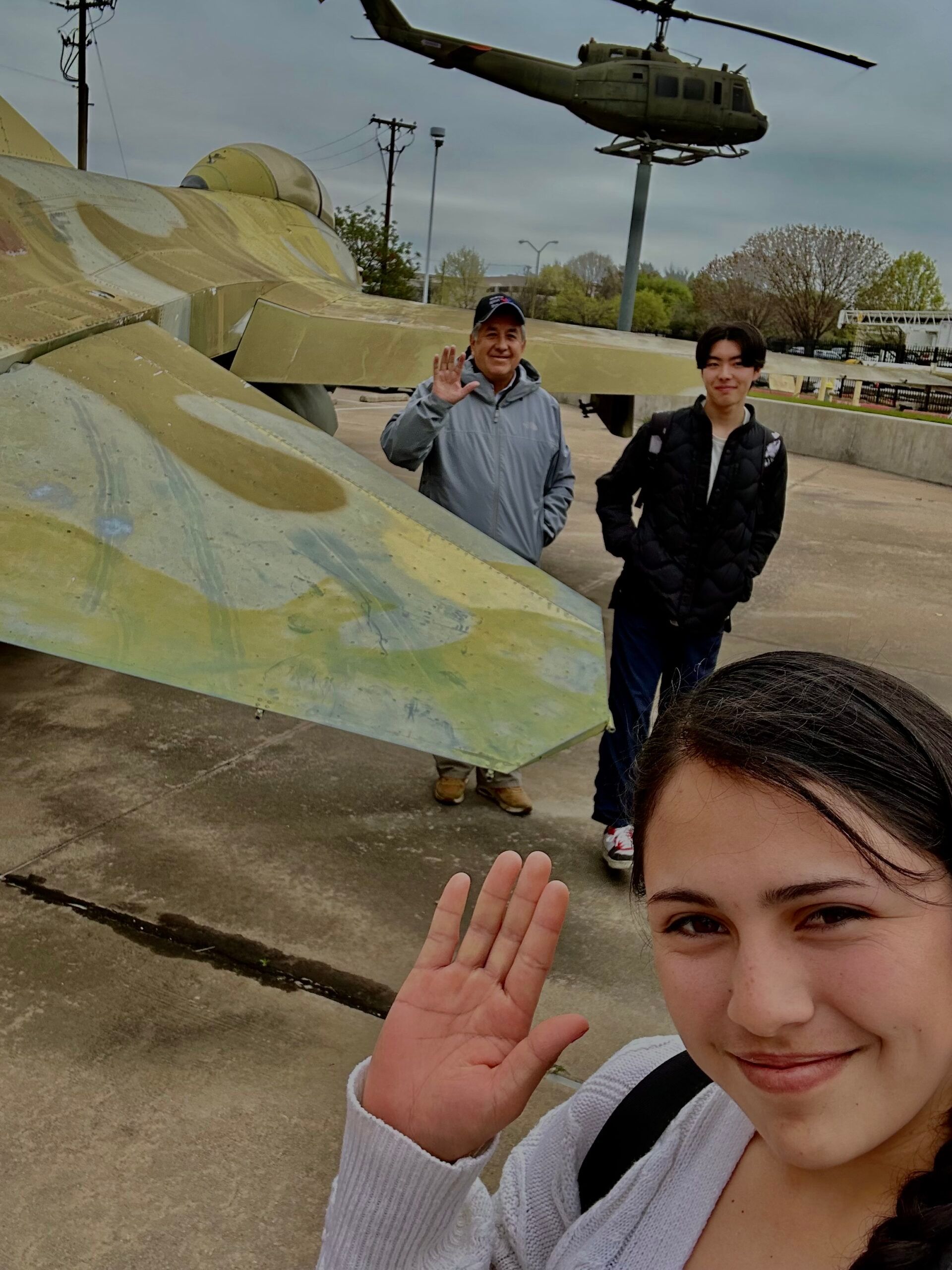 A group of young people are sitting at a table looking at a tablet.