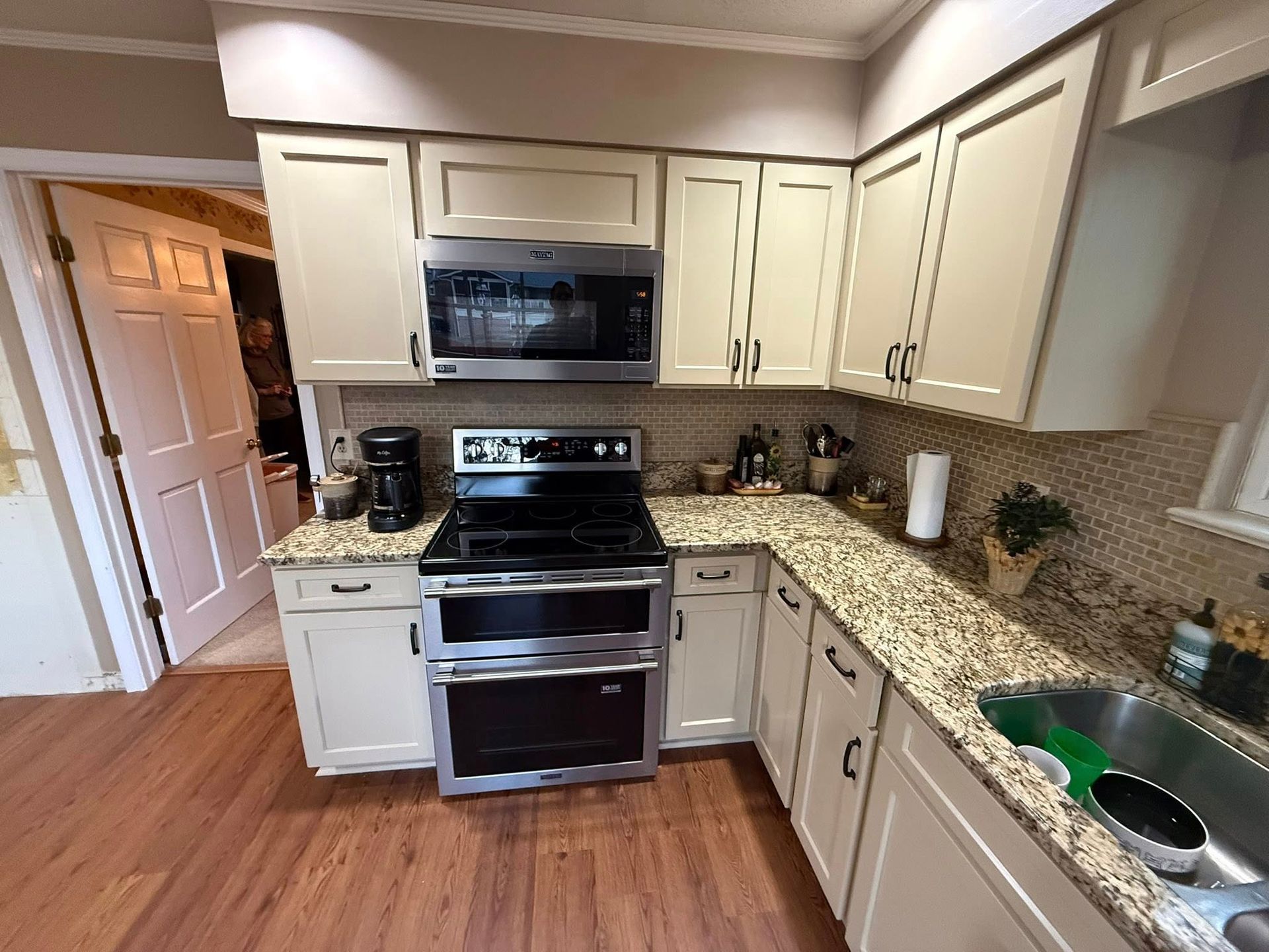 Kitchen with light cabinets, granite countertops, and stainless steel appliances.