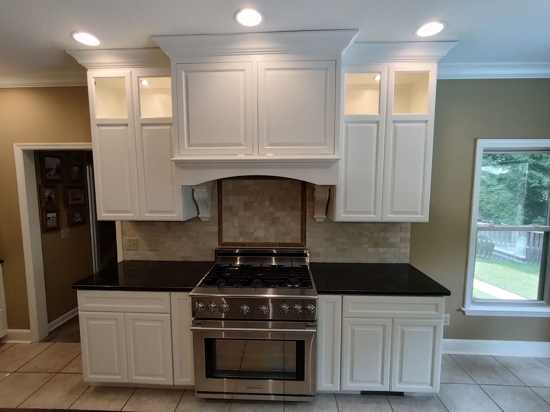 Kitchen with light cabinets, granite countertops, and stainless steel appliances.