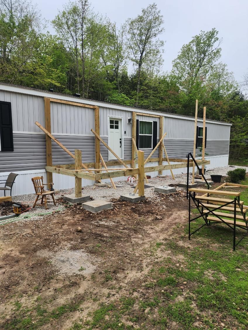 Mobile home with a partially built wooden deck. Construction in progress.